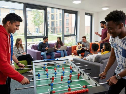 Gruppo eterogeneo di studenti universitari che socializzano e si divertono nella sala comune di una residenza universitaria (halls of residence), trasmettendo un senso di comunità.